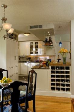 For this mid-range kitchen in a small two-bedroom apartment, Jennifer Gilmer Kitchen & Bath removed the wall separating the living room, dining room, and kitchen. To make up for lost space, the firm suspended a glass shelf above the peninsula.