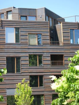 The horizontal bands are integral to the Corten steel siding:  each piece is bent into a 'v' at the bottom to conceal anchors and allow for expansion and contraction of the metal.