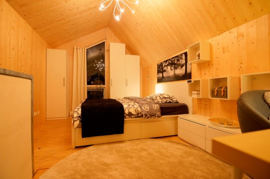 The loft-style bedroom stands alone on the second floor of the home and features built-in storage space.