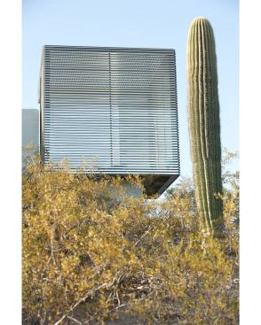 The cube cantilevers beyond the garden wall.