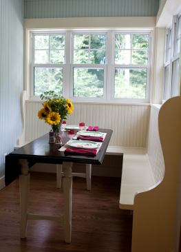 The built-in breakfast nook is surrounded by windows.