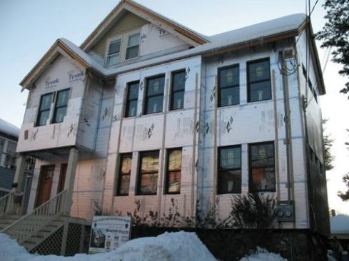 The complete house wrapped in foam board and furring strips.