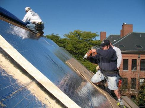 Workers screwing in the sheathing to the foam.