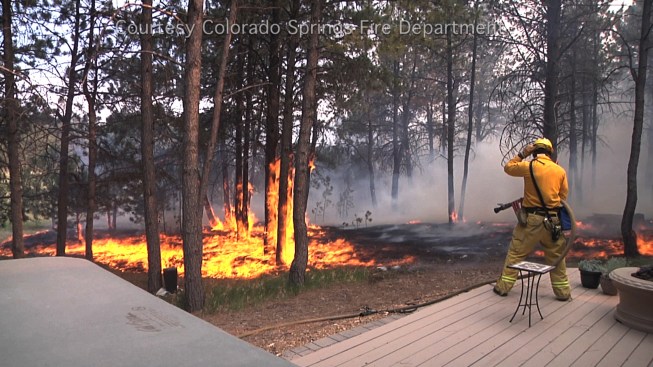 Appropriate pruning and thinning of trees and shrubs near a home helps firefighters suppress fire as the wildfire front approaches the structure. Above, a Colorado Springs firefighter successfully defends a house during the 2013 Black Forest fire, which destroyed more than 500 homes. The truck and crew worked for hours at this location, carefully rationing their limited water supply, but saving the home as the flames crept along the ground through the area.