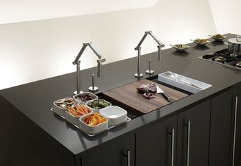 KohlerThe manufacturer used culinary expertise from its hospitality division to develop the Chef Inspired Collection of stainless steel kitchen sinks. The first product in the line, Stages, was designed around the French culinary concept of mise en place, so the sink comes standard with built-in storage and a variety of accessories. It includes a utensil tray; a dual-sided flip tray for use as a cutting board and serving tray; a separate cutting tray; a wire rack to protect the sink's basin; and ceramic bowls. An integral storage rack attaches to the underside of the sink for out-of-sight storage. The sink comes in two sizes. www.kohler.com.