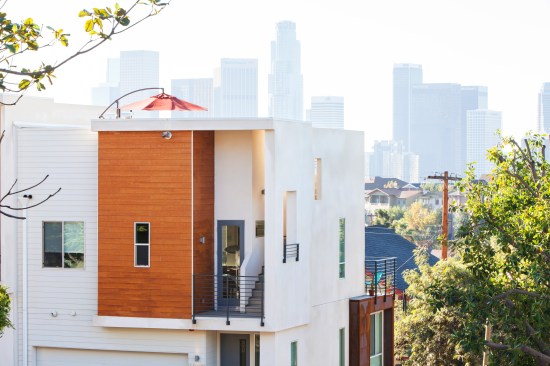 Stairs lead from the top-floor public spaces to a rooftop deck with downtown LA views.