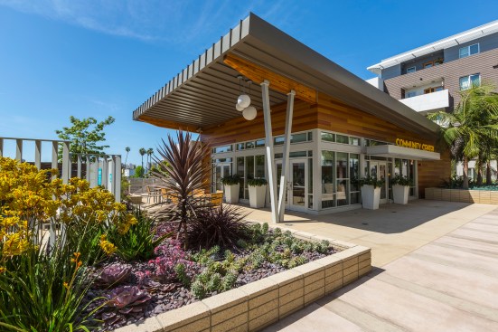 A butterfly roof distinguishes the theater, and its warm stain matches the wood doors on the units. 