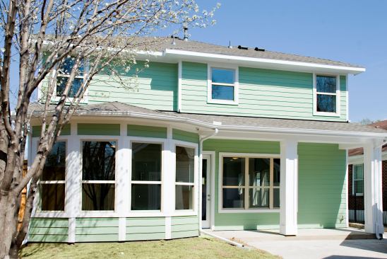 The house includes a detached garage and a driveway that goes into the backyard. The concrete mixture contains 51% fly ash, which lightens the color and helps reduce heat absorption.