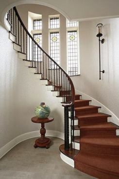 The beautifully renovated foyer and stairway to the second floor feature the existing railing as well as windows restored with art glass panels by Monarch Studios.