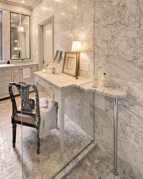 The dressing table counter slices through the shower glass to become a shelf with a scalloped soap dish and grooved drains along the edge.