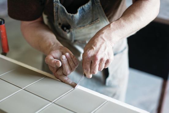 Pete Jochimsen, production manager at North Prairie Tileworks, cuts the clay into 4x4 squares after it has been pressed in Minneapolis, Minn., on May 28, 2014. 