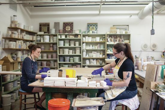 Natalie Stockdale, left, and Marie Anderson glaze tiles before firing them in the kiln. 