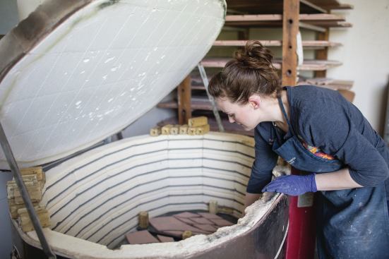 Natalie Stockdale places glazed tiles into the kiln to be fired. 