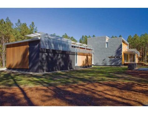 Jury Selections - Third Place:  GREENville House, Greenville, N.C.  Architect: Vinny Petrarca, Tonic Design  Builder: Tonic Construction  Architect’s description:  The 
GREENville House/Walters Residence is composed of two primary design components: bars and panels. Each part works together to generate an environmentally sensitive response. Narrow bars branch out into the landscape to create courtyards, capture natural light, allow cross ventilation, and intersect to form a central volume of double-height public space. A structural system holding photovoltaic panels and perforated screens is responsible for creating the home’s energy and hot water while shading openings to alleviate unnecessary heat gain.     Jurors’ comments:  A large and ambitious house with many materials and details. Well-proportioned and vigorous, the house displays an uncommon passion for architecture. The materials and forms are stitched together like a beautiful quilt.