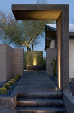 A double-cantilevered concrete wall delineates the carefully manicured space's point of entry.