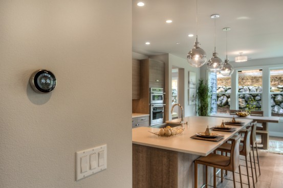 A close-up of the Nest thermostat on the wall of a Quadrant home.