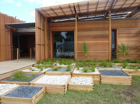 Modular planters in variegated heights connect the house to the surrounding landscape.