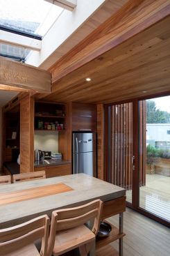 A triple-glazed skylight and large bi-fold doors illuminate the central section of the house.