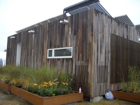 Louvered panels covering the windows on opposite sides of the house swing open in colder months to bring in additional light and radiant heat.