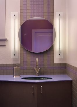 Beautiful lighting fixtures don’t always need to be fancy. This custom appointment was made from reclaimed glass found in an old medicine cabinet, a used compact disk, kitchen cabinet pulls, and other odds and ends. But humble materials aside, its simple design offers white light on both sides of the vanity while the design fits in perfectly with the bathroom’s Art Deco décor. Architect: Randall Comfort, St. Louis Builder: ARC works, St. Louis