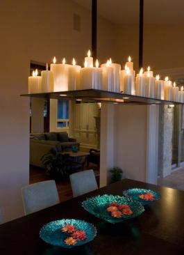 A refined version of gathering around the campfire, this chandelier’s candles offer flattering soft light, while additional downlighting on the underside of the fixture adds excitement to the table’s spread. Architect: Jon Pankratz Architect, Fredericksburg, Texas Builder: Laughlin Homes and Restoration, Fredericksburg Interior Designer: Slaughterhouse Design, Fredericksburg