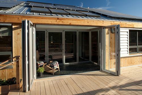 Nana Wall movable glass walls open up the sun porch for additional interior living space; when both sets are open, they provide ventilation while extending the living area outdoors.  