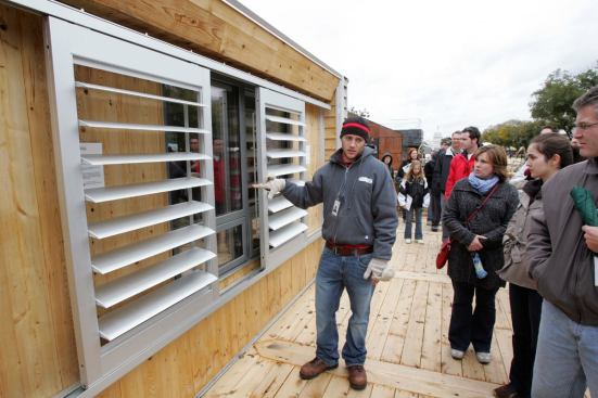 An Iowa team member shows off louvers on the outside of the windows that, when shut, keep heat and cold out better than interior shades.