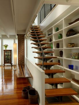 This airy steel and wood staircase allowed architects at Studio Agoos Lovera to maintain the 1953 home’s open plan while adding an updated aesthetic. Both in the staircase and throughout the home, warm woods and other organic materials were incorporated to balance out the home’s rectilinear character.