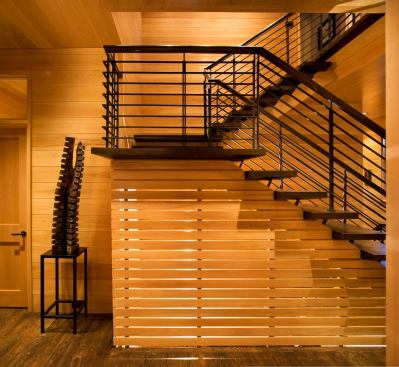 This beautiful staircase is homegrown in every good way. Using regionally harvested lumber, the teams at Carlton Architecture + DesignBuild and Cardinal Building Systems employed local artisans to lend their skill to the architectural woodwork seen here and throughout the home.