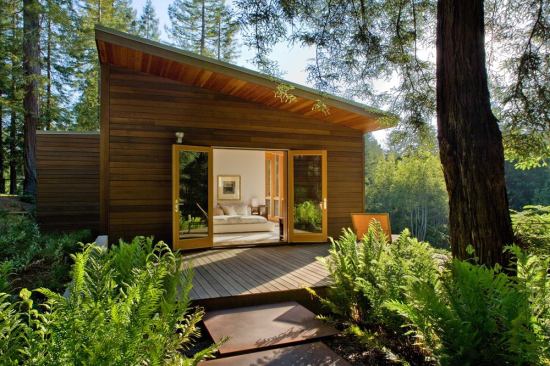The master bedroom opens onto a deck connecting it to a stand of redwood trees. 