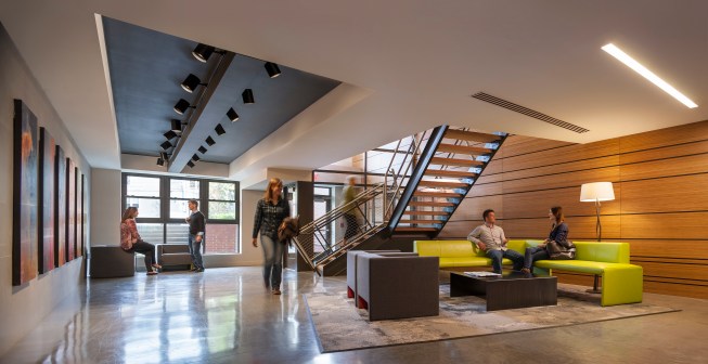 The "warehouse cool" aesthetic stands out in an enclave characterized by brick and stucco buildings. 
