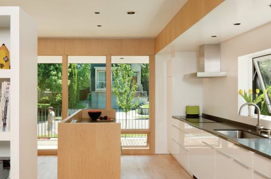 The first level’s walls and floor are covered in maple plywood, emphasizing the simple rectangular volume.