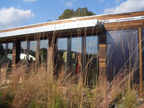 The solar awning on the southern-facing front of the Natural Fusion house combines passive shading with solar collection via PV modules on tracking louvers.
