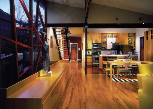 A splurge on Brazilian cherry flooring underscores the kitchen zone within the larger, maple-floored room.