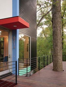 At the top of the gentle slope, a walkway leads from the sidewalk to this entryway on the deck, where a circular cutout gracefully accomodates a tree.