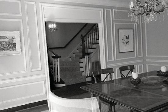 BEFORE: The existing view from the dining room to the main entry. The stairs, which turned out at the bottom, interrupted the flow down the hallway.                              
