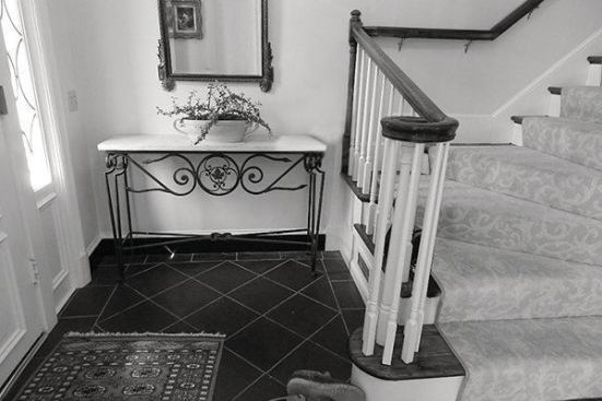 BEFORE: The existing main floor landing at the front entry way. The clients felt the wooden railing was dated and the turn blocked the pathway into the house.                            