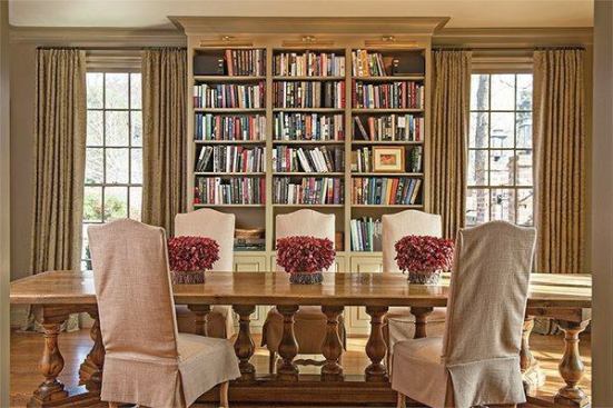 Custom bookcases between the windows and surrounding the entry door harken back to great libraries of the past while adding color and movement to the neutral palette in the room.