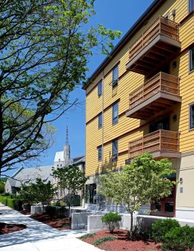 Pella Designer Series glass doors open up to balconies with Trex composite decking. Benches and blueberry bushes dot the landscape, where naturalized plantings eliminated the need for irrigation.