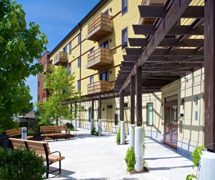 The building’s rear has a sheltered, village-like feel and faces a generous landscaped courtyard, formerly a church campus. Cable cross-bracing on the stainless-steel-and-fir pergola creates interesting shadow patterns.