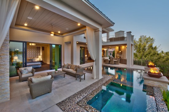 The master-suite lounge sits across the pool from the outdoor kitchen.