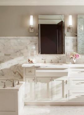 Adjustable mirrors and wall-mounted lighting fixtures create a three-dimensional composition at the sink wall. 
