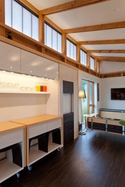 The open living space includes student-designed flexible furniture such as the rolling island/dining table/side board pieces.