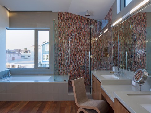 The same mosaic pattern runs throughout this modern beach home and gives life to a white bath. Project: Silver Strand Beach House by Robert Kerr Architecture Design, Inc.  