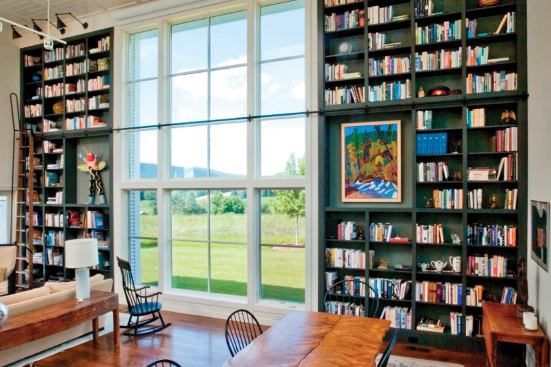 This custom home in the Berkshires has an abundance of bucolic views, and it makes sure none of them are wasted. Some of the vantage points are best enjoyed from breezy outdoor spaces. Others are framed with oversized Jeld-Wen picture windows like this one. The dark floor-to-ceiling bookcases on either side help to shape the window as a focal point. 
Builder: Albert J. Cummings General Contractor, Williamstown, Mass. 
Architect: Burr and McCallum Architects