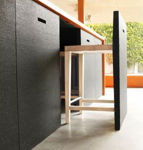 ...and a kitchen island made of recycled tires wrapped in orange Corian, with hideaway bar stools. 