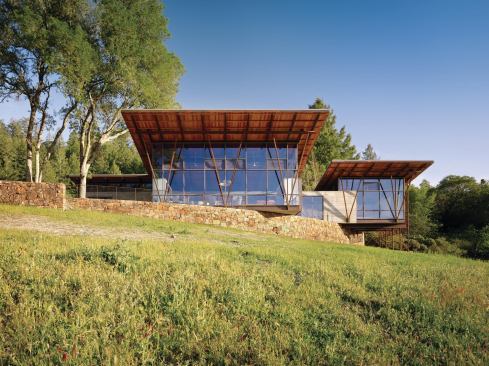 Long overhangs and high glass walls expose the compound’s wood-and-steel roof structure.