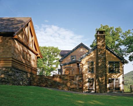Dark blue painted trim on the house—now sporting a cedar roof and siding—distinguishes it from the other buildings. 