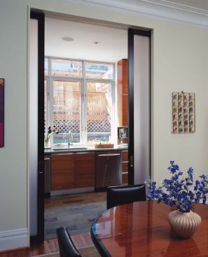 Translucent pocket doors help to mediate the modern kitchen and traditional dining room.