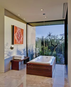 An ipe-clad bathtub and a wall-height glass window with garden views reinforces this master bath's connection to the outside. 